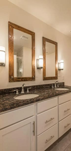 a bathroom with two sinks and two mirrors