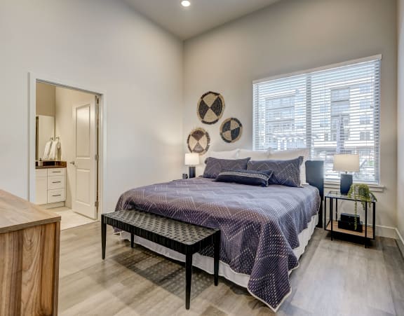 a bedroom with a bed and two windows