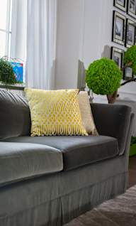 a couch with yellow pillows in a living room