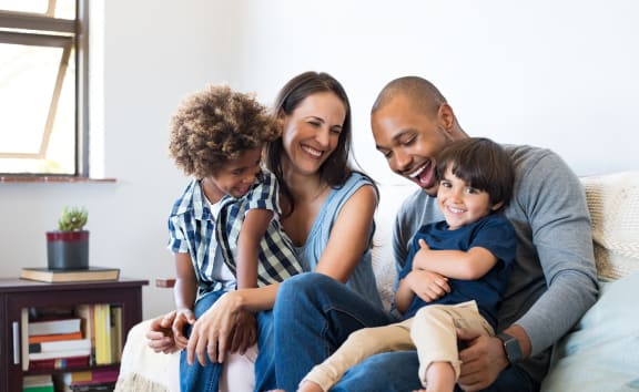 a family sitting on a couch with their children