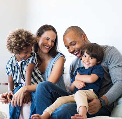 a family sitting on a couch with two children