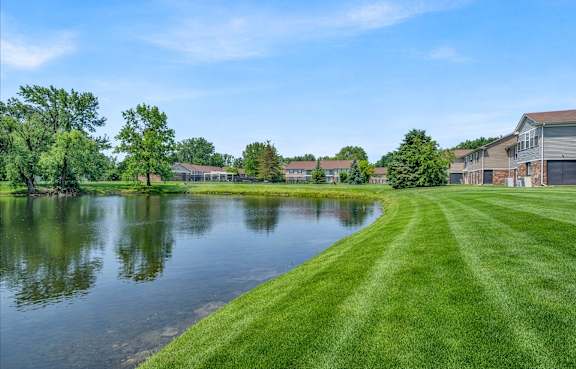 Serene landscape with a lake and grass at South Grove Apartments, Ann Arbor, MI