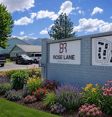 Rose Lane Apartments sign with a landscaped garden in front.