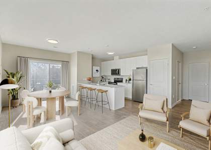 A modern living room with a kitchen in the background.