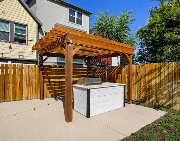A wooden pergola is attached to a white box.