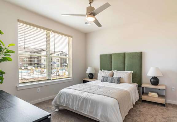 a bedroom with a large bed and a ceiling fan