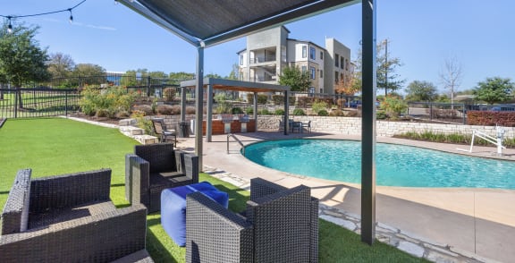 a backyard with a pool and patio with chairs and a canopy at Radius on Grove, Austin, TX