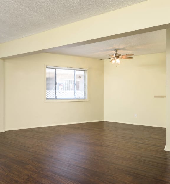 a bedroom with hardwood floors and two windows