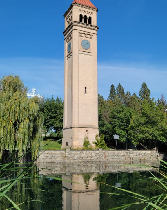 a tall clock tower next to a body of water