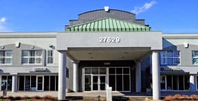 the front of a building with a green roof