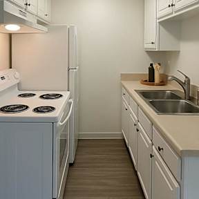 A kitchen with white appliances and cabinets.
