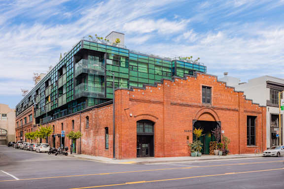 A red brick building with a green awning sits on a street corner.