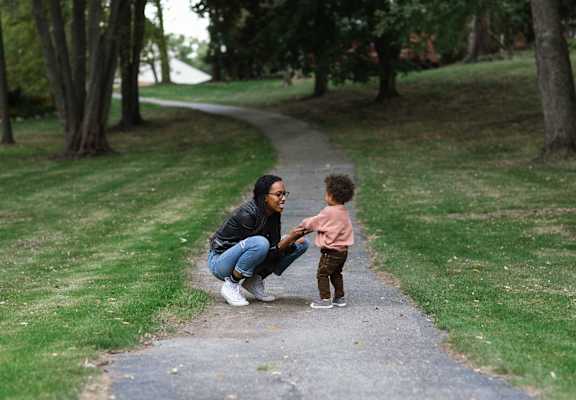 a woman and a child on a path in a park