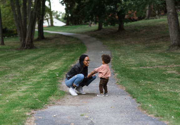 a woman and a child on a path in a park