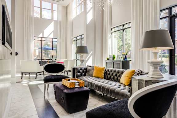 A modern living room with a grey sofa and a black and white chair.