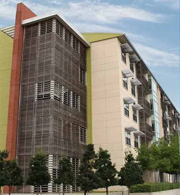 a tall building with a sky background and trees