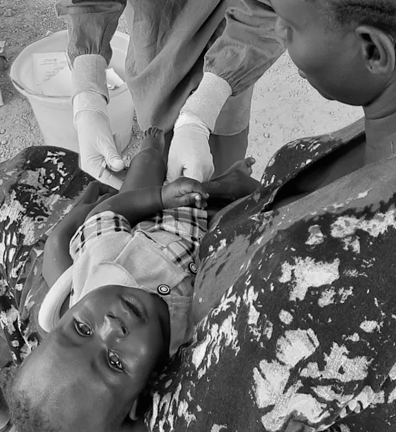 A man is giving a young boy a shot in his arm.