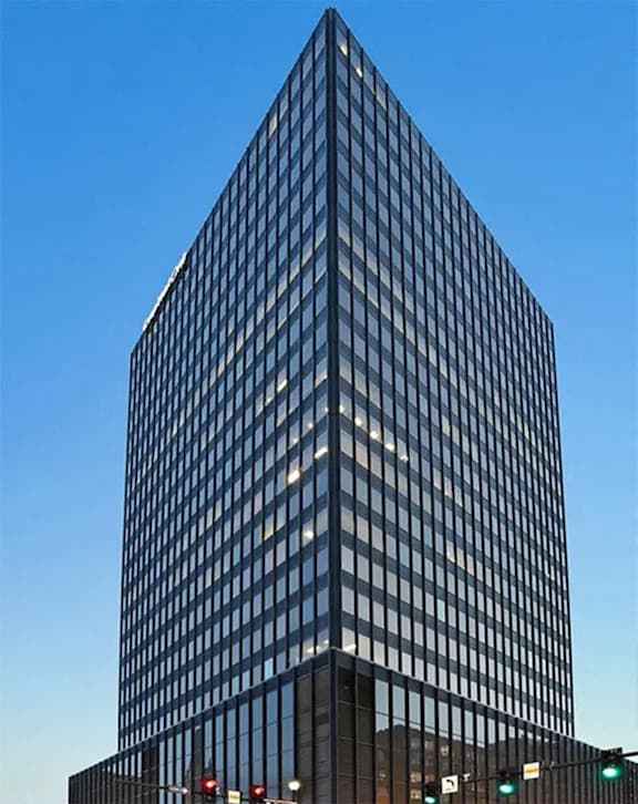 a tall office building in front of a blue sky