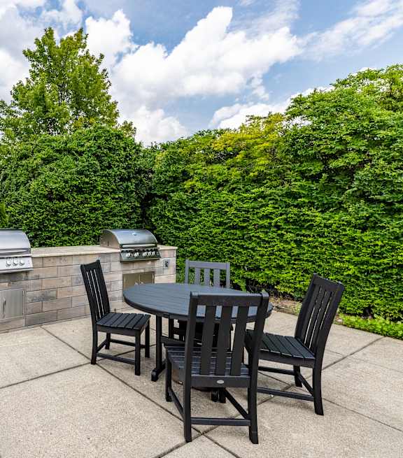 A patio with a table and chairs is set up outside a house.