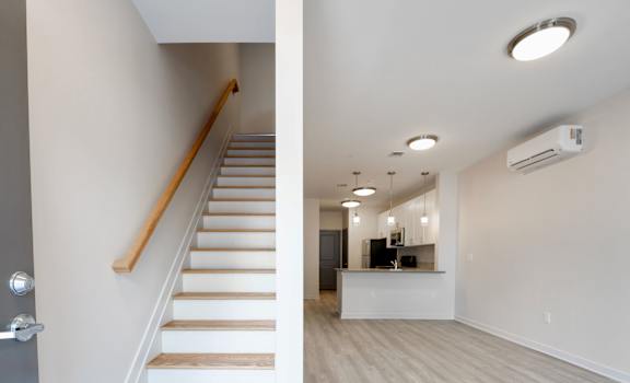A staircase with wooden steps and a white wall.