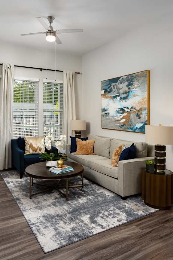 A living room with a couch, a coffee table, and a painting on the wall.