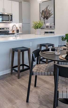 A kitchen with a table and chairs in the foreground.