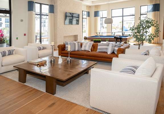 A living room with a white couch and a brown coffee table.