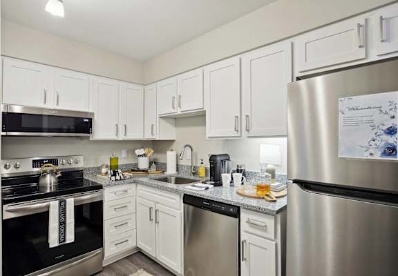 a kitchen with stainless steel appliances and white cabinets
