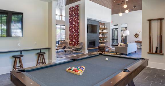 an open living room with a pool table and a fireplace