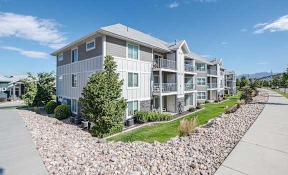 an exterior view of an apartment building next to a gravel pathway