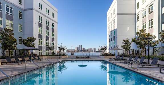 a large swimming pool in front of some tall buildings
