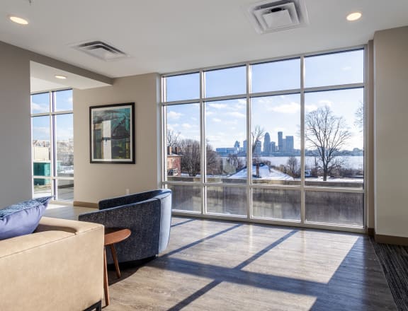 a living room with large windows and a view of the city