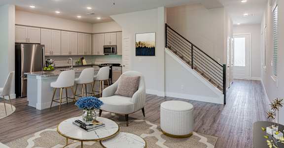 an open living room and kitchen with a spiral staircase