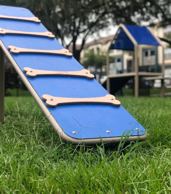 A blue plastic slide with wooden handles.