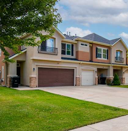 A two-story house with a garage and a driveway.