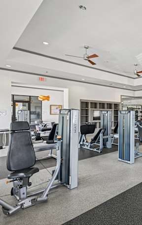 A spacious gym with a variety of equipment and a treadmill on the right side.