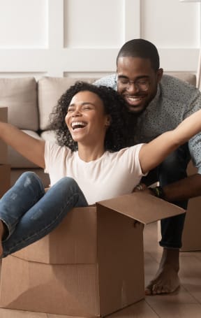 a man and woman sitting in a cardboard box