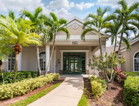a villa with palm trees in front of it