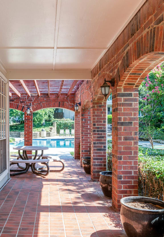 a covered porch with a table and a pool