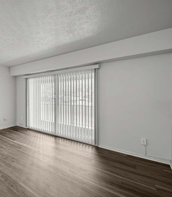 A room with wooden flooring and white walls.