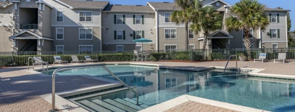 a swimming pool with an apartment building in the background