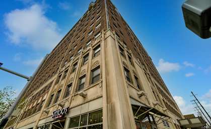 A tall building with a tattoo shop on the ground floor.
