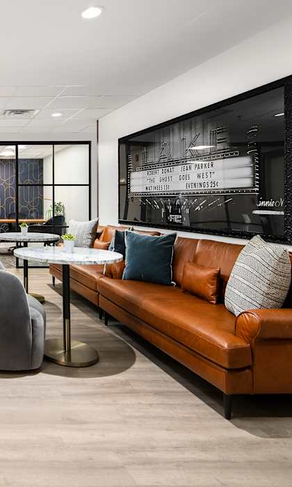 A modern office space with a long table, chairs, and a couch.