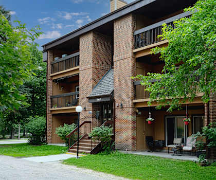 A brick apartment building with a balcony and a patio.