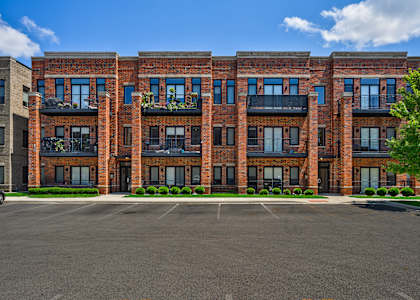 A large red brick building with a parking lot in front.