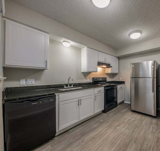 a kitchen with white cabinets and a stainless steel refrigerator