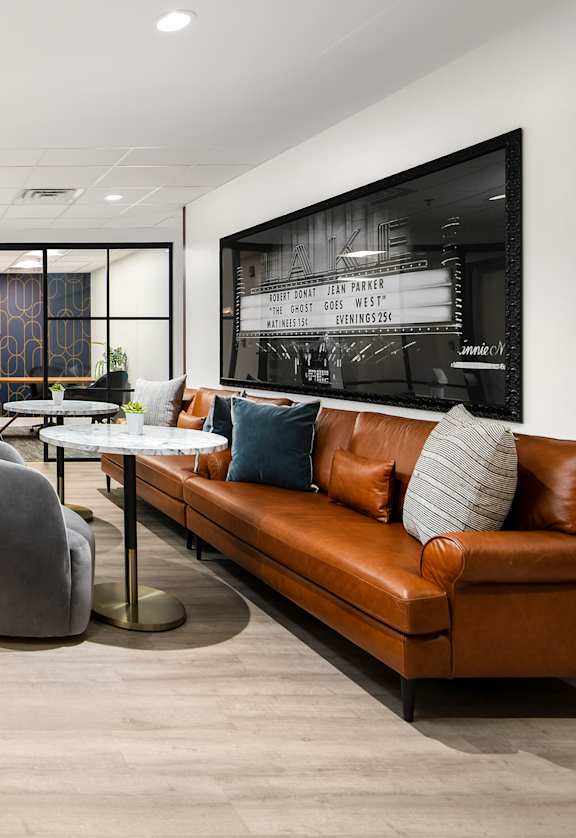 A modern office space with a long table, chairs, and a couch.