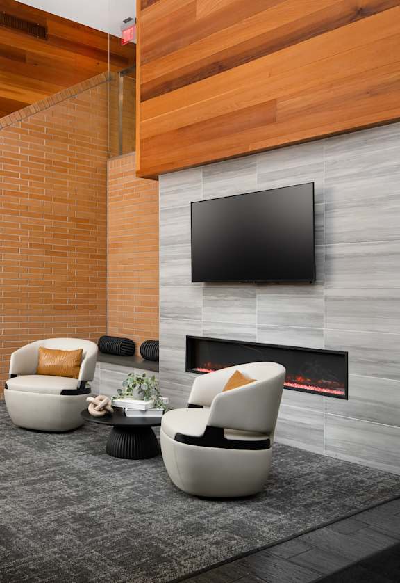 A modern living room with a fireplace and a flat screen TV mounted on the wall.