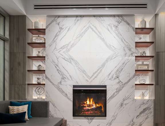 A modern living room with a fireplace and shelves.