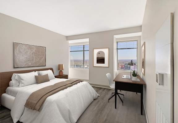 A bedroom with a large bed and a desk with a chair.